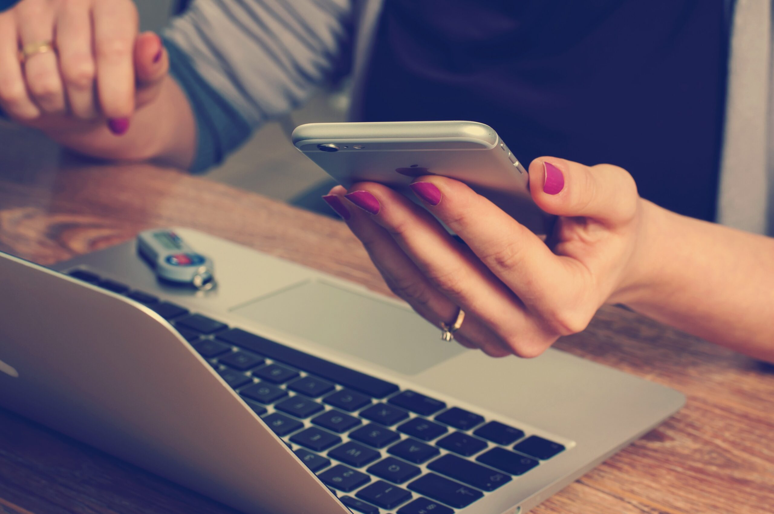 Person using a mobile phone and laptop to access online information and digital services