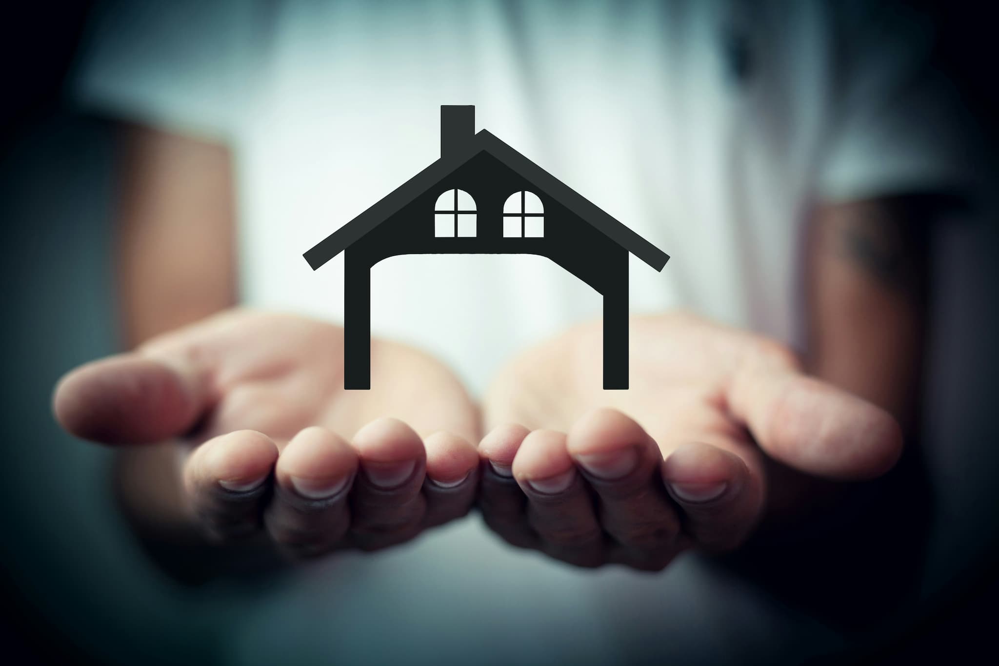 Hands holding a house symbol representing support and care for residents in accommodation