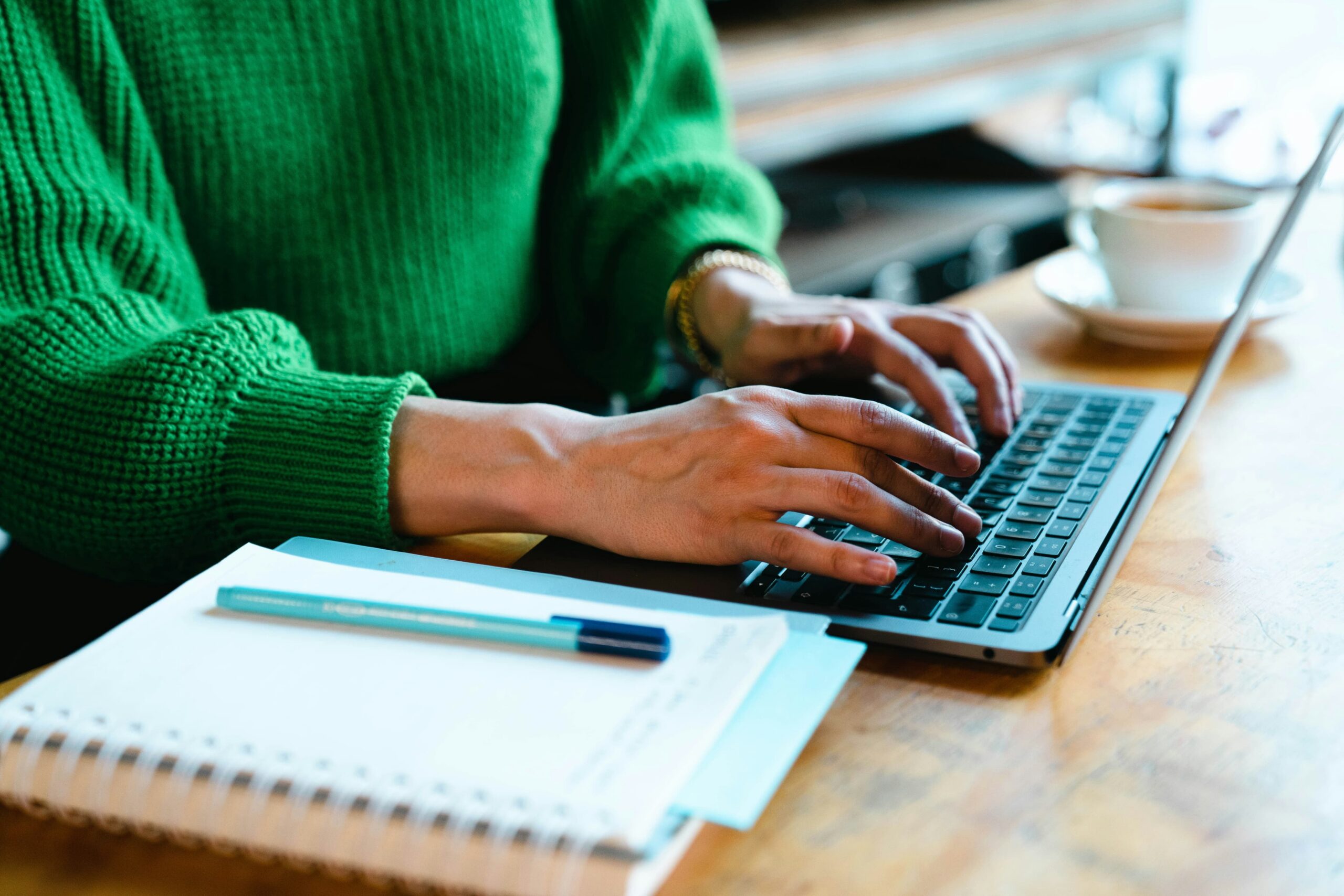 La persona está escribiendo el texto con el teclado del ordenador portátil